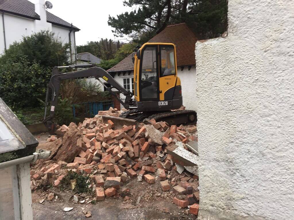 na slici ka mini bager na gomili cigala